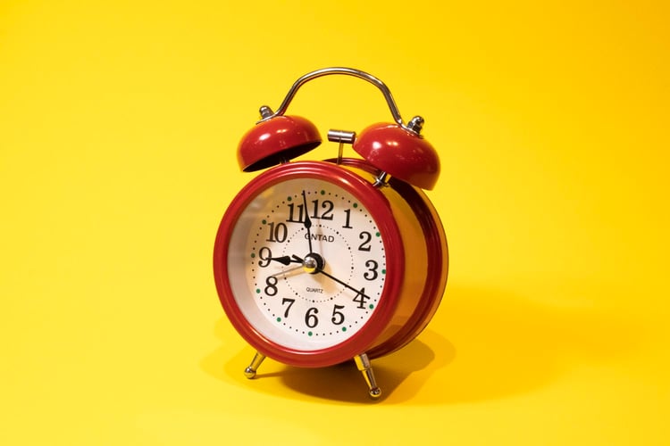 An alarm clock on a yellow background.